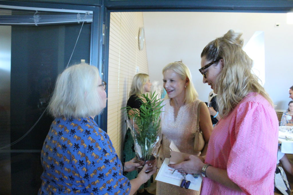 Terhi Heinilä ja Nina Kaipio vastaanottavat kasvin vieraalta.
